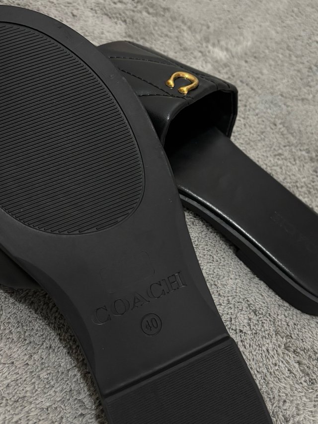 Chanclas Coach negras con detalle dorado