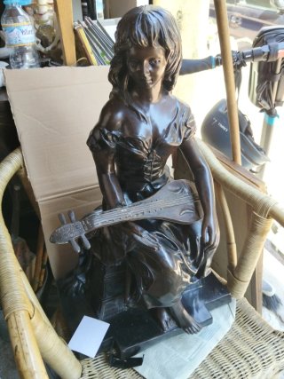 Escultura bronce mujer tocando instrumento