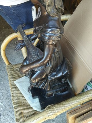 Escultura bronce mujer tocando instrumento