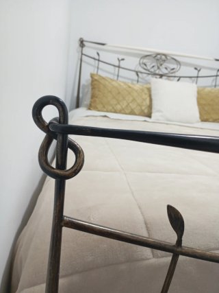 Cama de forja con adornos