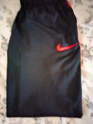 Pantalón chándal Nike negro y rojo.