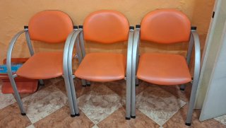 Tres sillas de peluquería naranja y plata