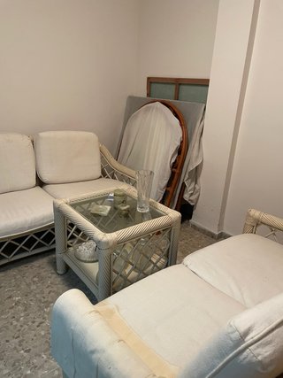 Sofá de mimbre y mesa de cristal