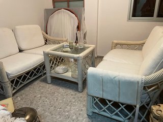 Sofá de mimbre y mesa de cristal