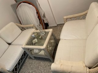 Sofá de mimbre y mesa de cristal