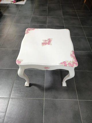 Mesa restaurada de madera blanca con flores rosas