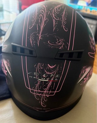 Casco de moto negro con diseño rosa
