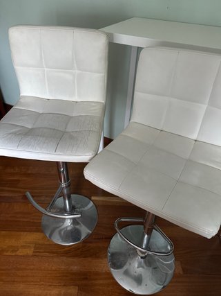 Mesa alta blanca con estanterías y 2 sillas