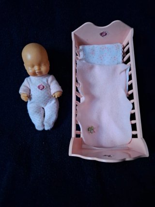 Cuna de juguete con muñeco bebé almohada y colcha