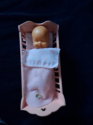 Cuna de juguete con muñeco bebé almohada y colcha