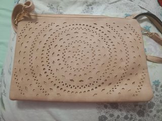 Bolso de mano beige con diseño calado