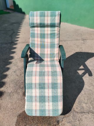 Tumbona plegable de resina verde con colchoneta.