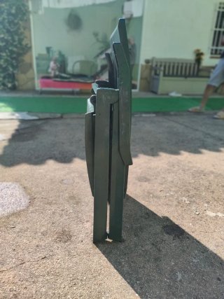 Tumbona plegable de resina verde con colchoneta.