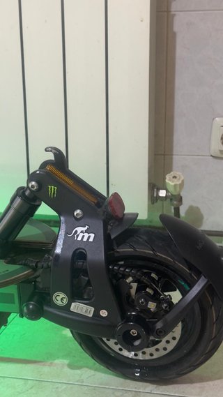 Patinete eléctrico verde con casco