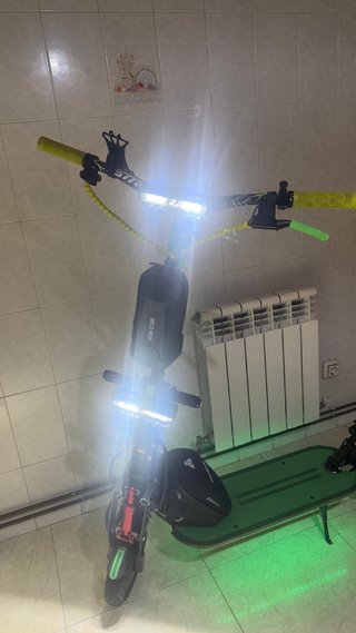 Patinete eléctrico verde con casco