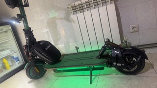 Patinete eléctrico verde con casco