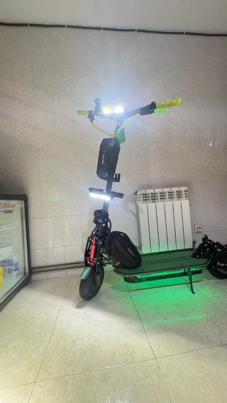 Patinete eléctrico verde con casco