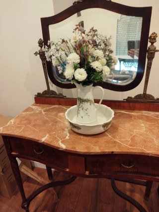 Mueble tocador clásico con espejo y mármol.