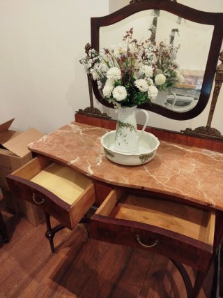 Mueble tocador clásico con espejo y mármol.