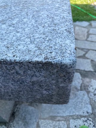 Mesa y bancos de piedra gris.