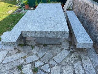Mesa y bancos de piedra gris.