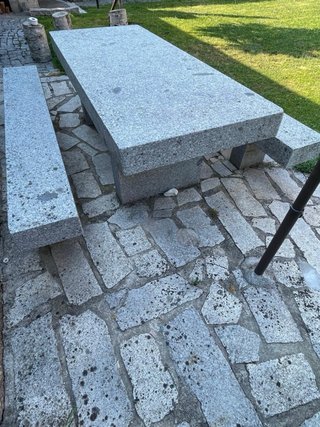 Mesa y bancos de piedra gris.