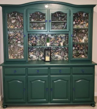 Mueble de salón verde con puertas de cristal.