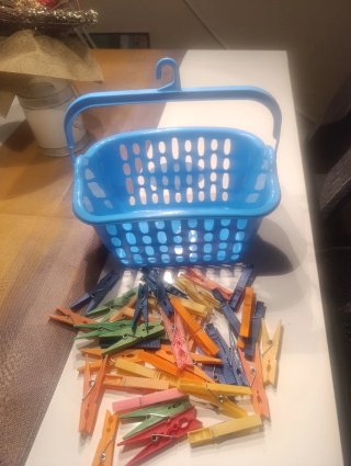 Cesto azul con pinzas para la ropa