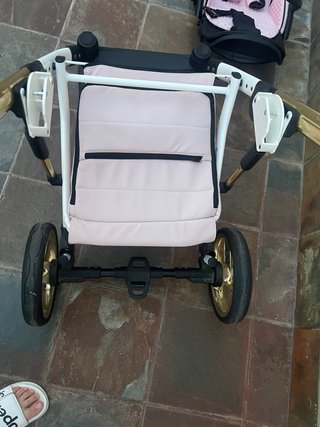Carro de bebé rosa y dorado
