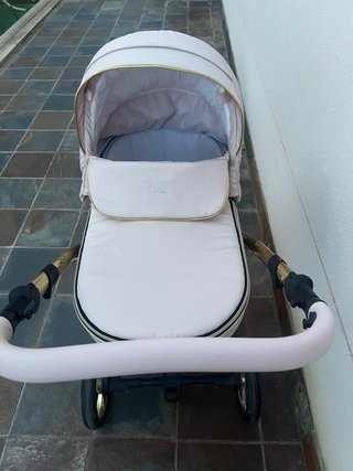 Carro de bebé rosa y dorado