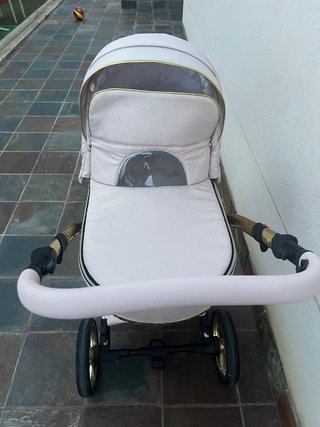 Carro de bebé rosa y dorado