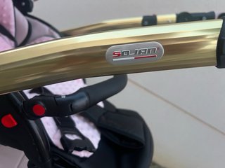 Carro de bebé rosa y dorado