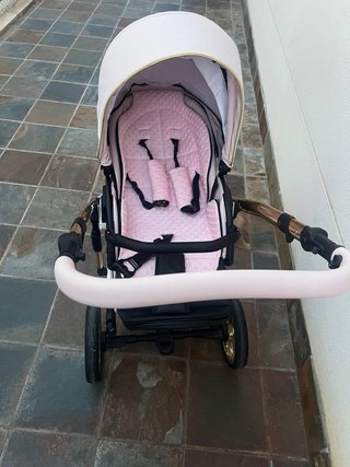 Carro de bebé rosa y dorado