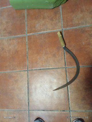 Hoz de metal con mango de madera