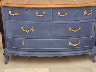Cómoda antigua pintada azul con herrajes dorados.
