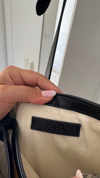 Bolso negro y dorado con detalle ovalado