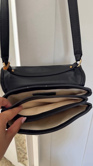Bolso negro y dorado con detalle ovalado