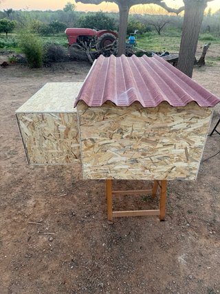 Gallinero de madera con tejado rojo