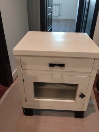 Mesita de noche blanca con cajón y puerta.Las dos