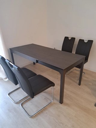 Mesa castanha com 4 cadeiras pretas