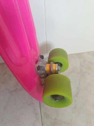 Monopatín rosa con ruedas verdes