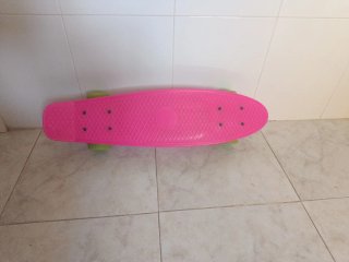 Monopatín rosa con ruedas verdes