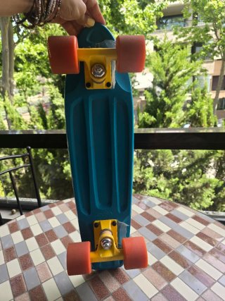 Patinete azul con ruedas naranjas
