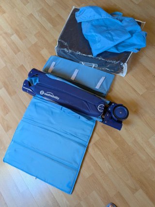 Cuna de viaje azul y colchón.