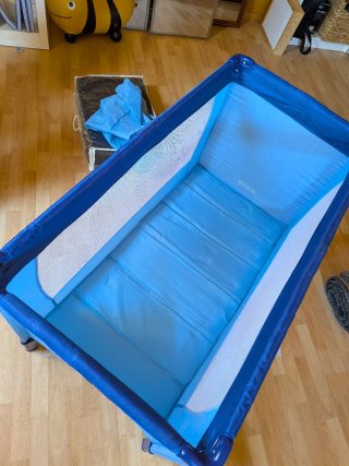 Cuna de viaje azul y colchón.