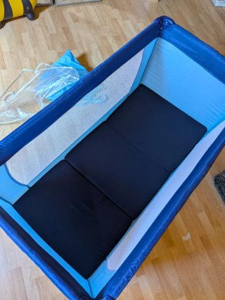 Cuna de viaje azul y colchón.