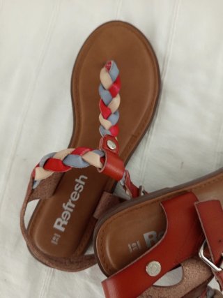 Sandalias planas trenzadas rojas y marrones.