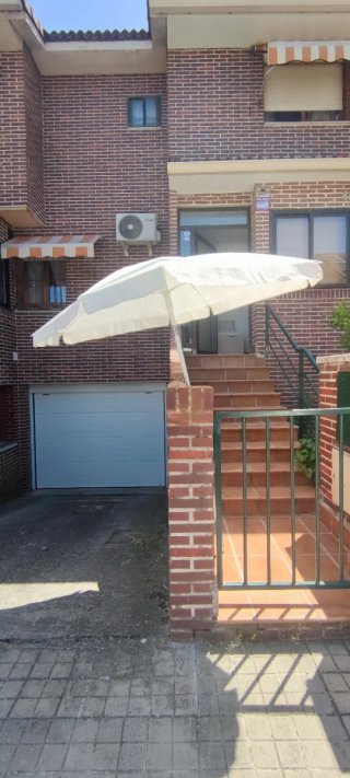 Sombrilla grande de tela beige, sin pedestal.