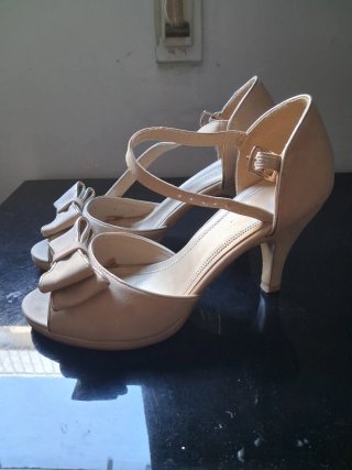 Zapatos de tacón beige con lazo dorado