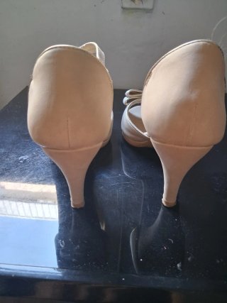 Zapatos de tacón beige con lazo dorado